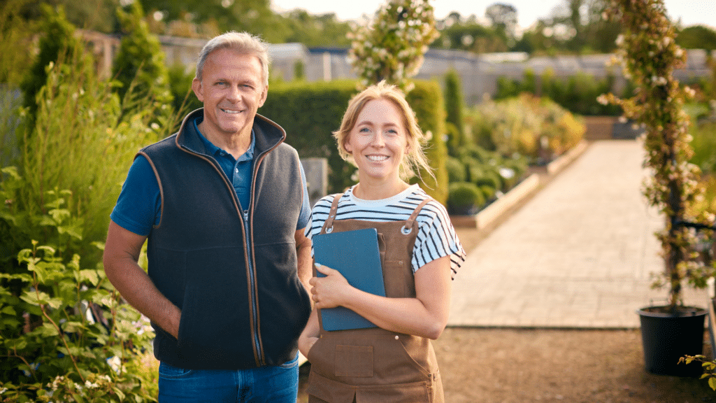Une designer paysagiste avec son client prenant la pose an extérieur