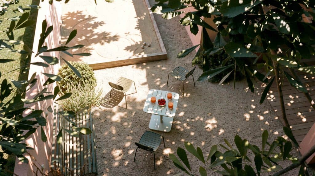 vue aérienne d'un aménagement paysager avec un terrain de pétanque, une table et quelques chaises